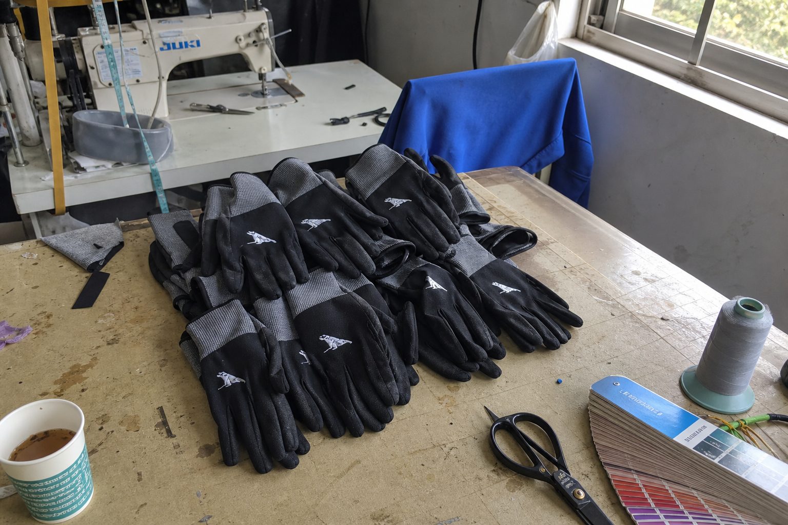 Stack of premium custom branded work gloves with embroidered company logos